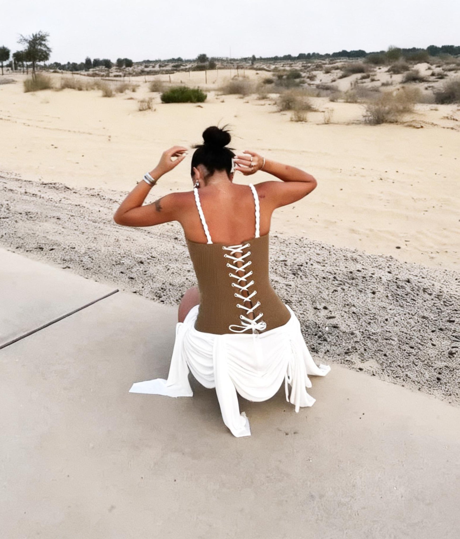 Back view of Laced-Up Corset Mini Dress in Brown featuring open-back lace-up corset detail
