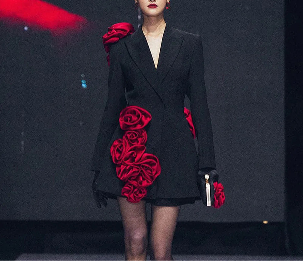 front view: "Model wearing womens black blazer dress with red flower details on runway