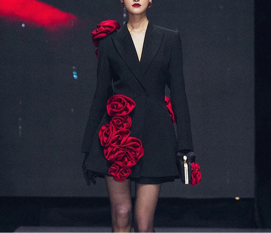 front view: "Model wearing womens black blazer dress with red flower details on runway